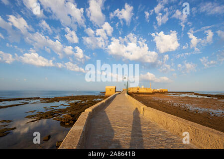 Paseo Fernando chinoni portando al Castillo de san sebastian a bassa marea nelle prime ore del mattino, Cadice, Andalusia, Spagna, Europa Foto Stock