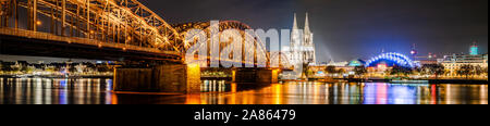 Panorama della città di Colonia di notte con la cattedrale di Colonia, ponte di Hohenzollern e il fiume Reno Foto Stock