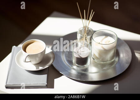 Caffè, candele e aroma diffusore reed sulla tavola Foto Stock