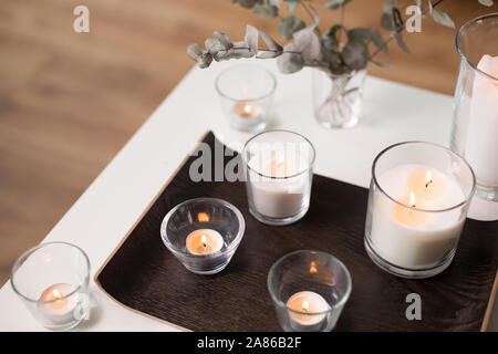 Le candele e i rami di eucalipto su tavola Foto Stock