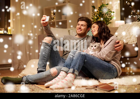 Coppia felice tenendo selfie tramite smartphone a casa Foto Stock