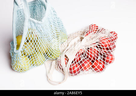 Mele biologiche in borsa di vimini per fare shopping su sfondo bianco, eco shopping bag il concetto. Foto Stock