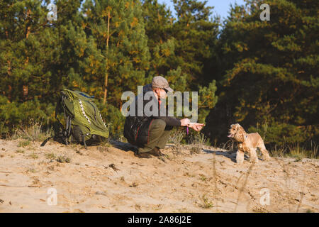 Tourist dispone di rompere con il cane e lo zaino nella foresta. Foto Stock