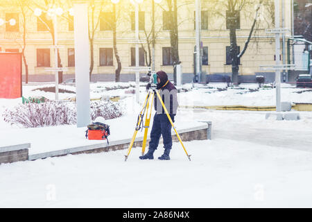 Ingegnere geometra utilizza una stazione totale in corrispondenza di un sito in costruzione. Rilevamenti geodetici. Costruzione Edilizia Foto Stock