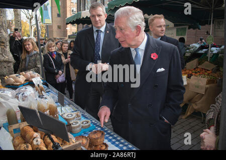 Il principe Carlo cammina per incontrare e salutare, le sue guardie del corpo dei dettagli della sicurezza sono dietro di lui. Swiss Cottage Farmers Market, detentori di bancarelle. E' il ventesimo anniversario del mercato agricolo di Londra. Il principe Carlo e la duchessa di Cornovaglia hanno fatto visita. 2019 per commemorare l'evento. HOMER SYKES anni '2010 Foto Stock