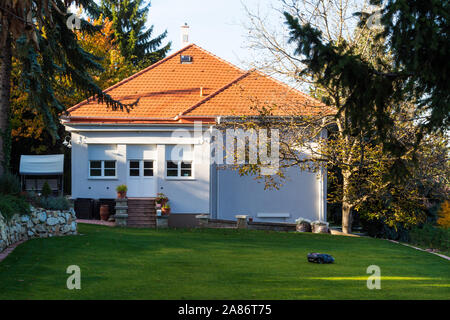 Robotica Robot tosaerba la falciatura di erba nel giardino di casa, Sopron, Ungheria Foto Stock