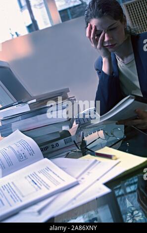 Business donna sopraffatti da un eccesso di abbondanza di documentazione Foto Stock