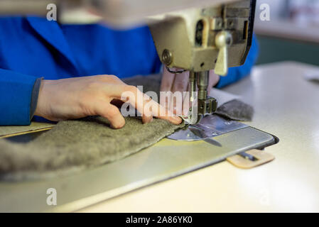 I dettagli di cucitura di pelliccia e cuoio. Produzione di calzature. Foto Stock