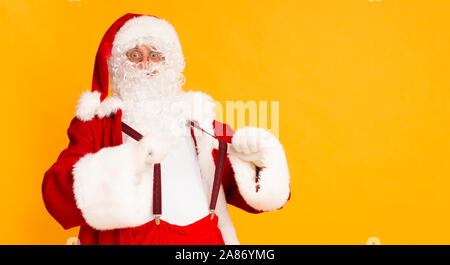 Funny Santa che mostra il suo Natale autoreggenti su Orange Foto Stock
