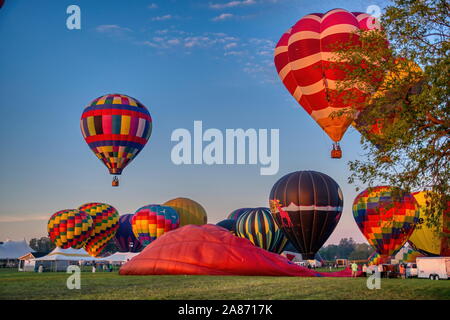Hot Air Balloon Festival mattina, Sunrise lancio di palloncini multipli su una soleggiata mattina d'estate Foto Stock