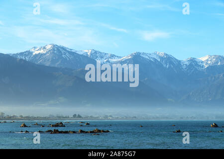 Spiaggia rocciosa a Kaikoura, vista montagne, Isola del Sud,Nuova Zelanda Foto Stock