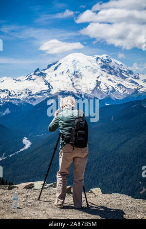 Un fotografo con il setup del treppiede per scattare foto di Mount Rainier's East Side da Crystal Mountain Resort il vertice di Washington, Stati Uniti d'America. Foto Stock