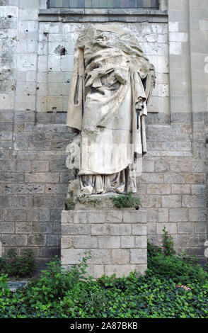 Un danneggiato statua si trova al di fuori della cattedrale di Arras, Francia (Cathédrale Notre-dame et Saint-Vaast). La chiesa ha subito danni in entrambe le guerre mondiali. Foto Stock