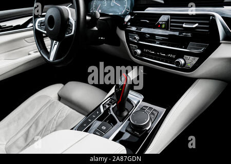 Il lusso moderno bianco auto con interni in pelle naturale pannello di legno. Una parte della pelle sedile di vettura con i dettagli di cucitura. Interno con il cruscotto. Perf bianco Foto Stock