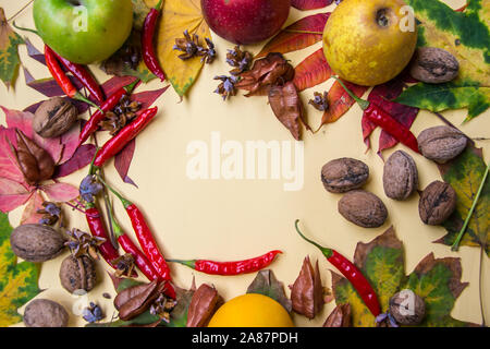 Grappolo di foglie colorate, baccelli, cibo e i dadi su sfondo giallo, still life spazio copia, vista dall'alto autunno composizione, il posto per il testo Foto Stock