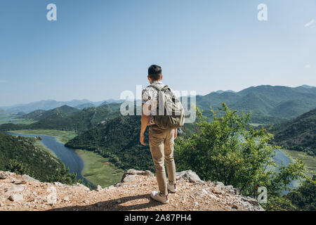 Un turista o un viaggiatore con uno zaino si ammira una bellissima vista del paesaggio naturale e della fauna selvatica in Montenegro. Foto Stock