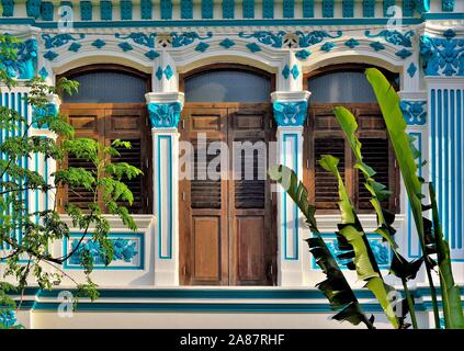 Bella bottega tradizionale con finestre ad arco, antichi in legno marrone e persiane blu e bianco esterno nel centro storico di Joo Chiat, Singapore Foto Stock