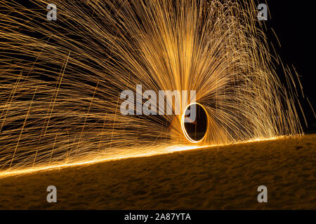 Fire ballerini Swing fire spettacolo di danza di notte fire visualizza sulla spiaggia uomo danza giocoleria con fuoco , Koh Samet, Thailandia. Foto Stock