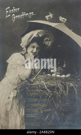 Vintage fotografia cartolina con auguri pasquali, Donna sorridente con ombrello guardando le uova nel fieno, pubblicato negli Stati Uniti nel 1908 Foto Stock