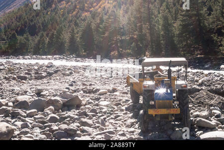 Dazi autonomi dumper costruzione veicolo parcheggiato sul sito industriale sulla banca del fiume di Beas in Manali India con sfondo di montagna per costruire il Foto Stock