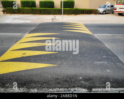 Street speed bump in strada per la sicurezza verniciati con colore giallo Foto Stock