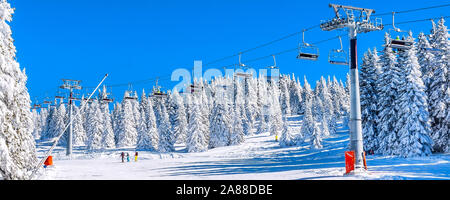 Panorama di ski resort, pendenza sciatori sulla seggiovia, il bianco della neve di alberi di pino, Kopaonik, Serbia Foto Stock