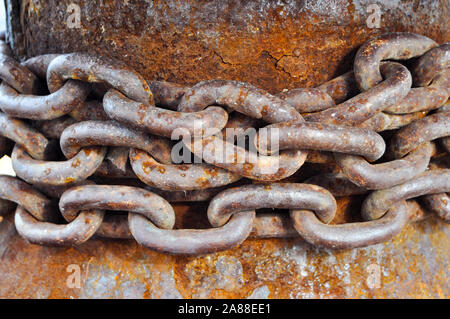 Vecchie e arrugginite post di ormeggio con vecchio arrugginito catena sul dock di calcestruzzo del porto Foto Stock