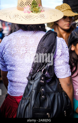 Local donna indossa un cappello di fantasia mentre si cammina sul mercato vecchio (o Mercado 25 de Mayo) strade a Cochabamba, in Bolivia Foto Stock