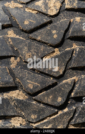 Vista ravvicinata della vecchia gomma usati terreno di fango con pneumatici usurati resistente ai fenomeni di usura del battistrada. Fangoso nero sport utility pneumatico del veicolo Foto Stock