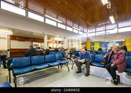 Area di ricevimento in ospedale NHS o medico della sala di attesa con il paziente Foto Stock