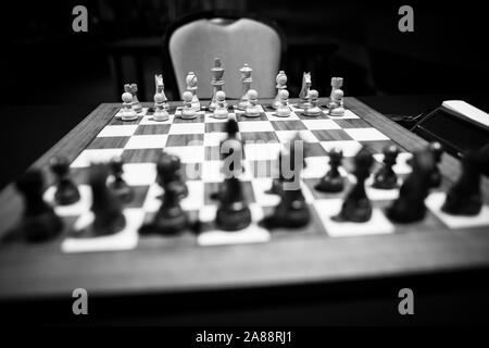 Monocromatico profondità di campo (messa a fuoco selettiva) immagine con scacchi in legno pezzi su un tavolo di legno prima di un concorso professionale. Foto Stock