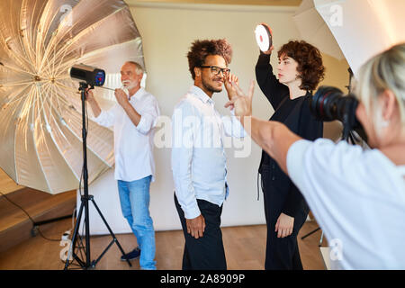 Fotografo di team e il modello di preparare la luce per scattare la foto Foto Stock