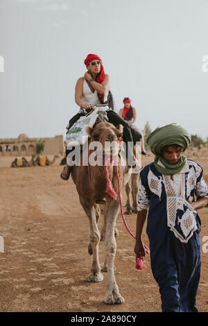 Deserto del Sahara, Marocco - Settembre 18th, 2019: un riff uomo guida di una carovana di cammelli con i turisti per le dune del deserto, durante l esperienza di avventura Foto Stock