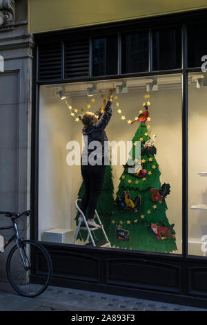 Finestra dresser preparazione vetrina di Natale per visualizzare Sussex Street Cambridge Città 2019 Foto Stock