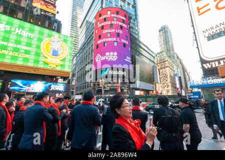 I dipendenti con le loro famiglie e i loro amici a raccogliere il gigantesco schermo video sul Nasdaq stock exchange in Times Square a New York decorato per il debutto della rete FangDD Gruppo (duo) offerta pubblica iniziale su Venerdì, 1 novembre 2019. Rete FangDD Group è un servizio online di real estate marketplace in Cina offrendo strumenti su una piattaforma mobile per gli agenti immobiliari. (© Richard B. Levine) Foto Stock