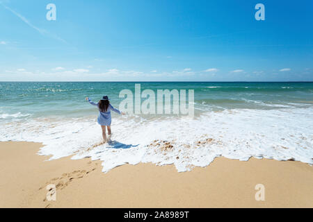 Donna che cammina sulla spiaggia a Lisbona, Portogallo Foto Stock