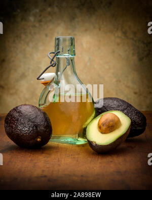 Avocado con bottiglia d'olio Foto Stock