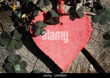 La foto mostra un cuore rosso sul terreno in legno Foto Stock