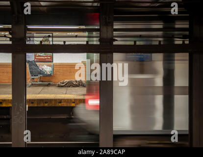 Un senzatetto uomo dorme nella 116San la stazione della metropolitana di New York di Domenica, 3 novembre 2019. (© Richard B. Levine) Foto Stock