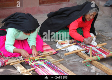 Le donne di tessitura Waistbands Calendario su Taquile Island, il lago Titicaca, Perù Foto Stock