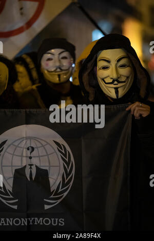 I membri di anonimo la Catalogna e i sostenitori di Julian Assange indossare maschere dimostrare durante la maschera di milioni di marzo a Barcellona. Foto Stock