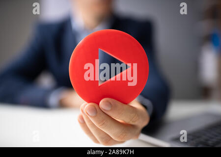Close-up di una mano di un uomo azienda Red Icona Riproduci Foto Stock