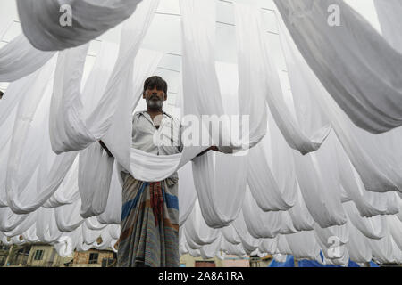 Narayanganj, Bangladesh. 7 Nov, 2019. I lavoratori del Bangladesh raccogliere tessuto dopo asciugare sotto il sole in una fabbrica di tintura in Narayanganj, vicino a Dacca in Bangladesh, 7 novembre 2019. Credito: Suvra Kanti Das/ZUMA filo/Alamy Live News Foto Stock