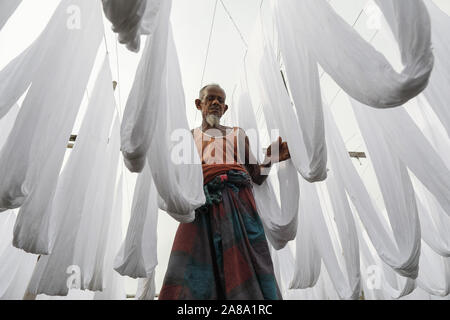 Narayanganj, Bangladesh. 7 Nov, 2019. I lavoratori del Bangladesh raccogliere tessuto dopo asciugare sotto il sole in una fabbrica di tintura in Narayanganj, vicino a Dacca in Bangladesh, 7 novembre 2019. Credito: Suvra Kanti Das/ZUMA filo/Alamy Live News Foto Stock