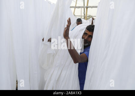 Narayanganj, Bangladesh. 7 Nov, 2019. I lavoratori del Bangladesh raccogliere tessuto dopo asciugare sotto il sole in una fabbrica di tintura in Narayanganj, vicino a Dacca in Bangladesh, 7 novembre 2019. Credito: Suvra Kanti Das/ZUMA filo/Alamy Live News Foto Stock