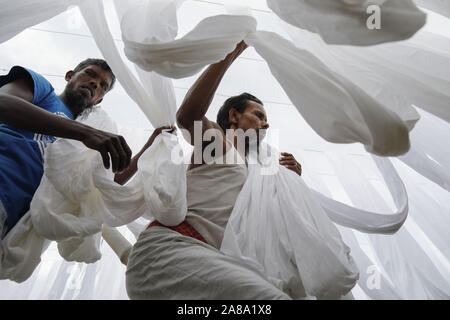 Narayanganj, Bangladesh. 7 Nov, 2019. I lavoratori del Bangladesh raccogliere tessuto dopo asciugare sotto il sole in una fabbrica di tintura in Narayanganj, vicino a Dacca in Bangladesh, 7 novembre 2019. Credito: Suvra Kanti Das/ZUMA filo/Alamy Live News Foto Stock