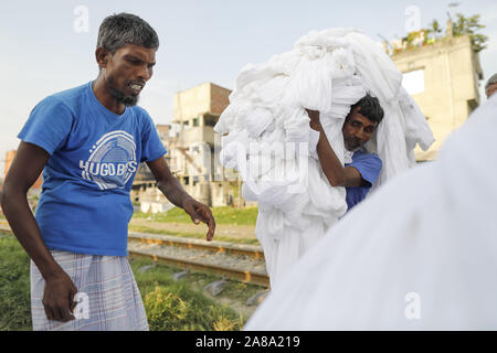 Narayanganj, Bangladesh. 7 Nov, 2019. I lavoratori del Bangladesh raccogliere tessuto dopo asciugare sotto il sole in una fabbrica di tintura in Narayanganj, vicino a Dacca in Bangladesh, 7 novembre 2019. Credito: Suvra Kanti Das/ZUMA filo/Alamy Live News Foto Stock