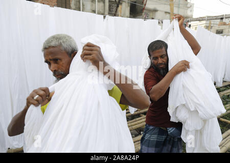 Narayanganj, Bangladesh. 7 Nov, 2019. I lavoratori del Bangladesh raccogliere tessuto dopo asciugare sotto il sole in una fabbrica di tintura in Narayanganj, vicino a Dacca in Bangladesh, 7 novembre 2019. Credito: Suvra Kanti Das/ZUMA filo/Alamy Live News Foto Stock