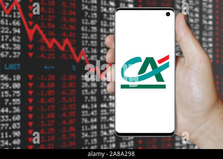 Il logo della società pubblica Crédit Agricole visualizzato su uno smartphone. Stock negativi sullo sfondo del mercato. Credito: PIXDUCE Foto Stock