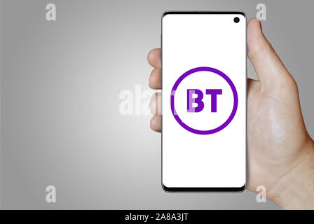 Il logo della società pubblica BT Group visualizzata su uno smartphone. Sfondo grigio. Credito: PIXDUCE Foto Stock